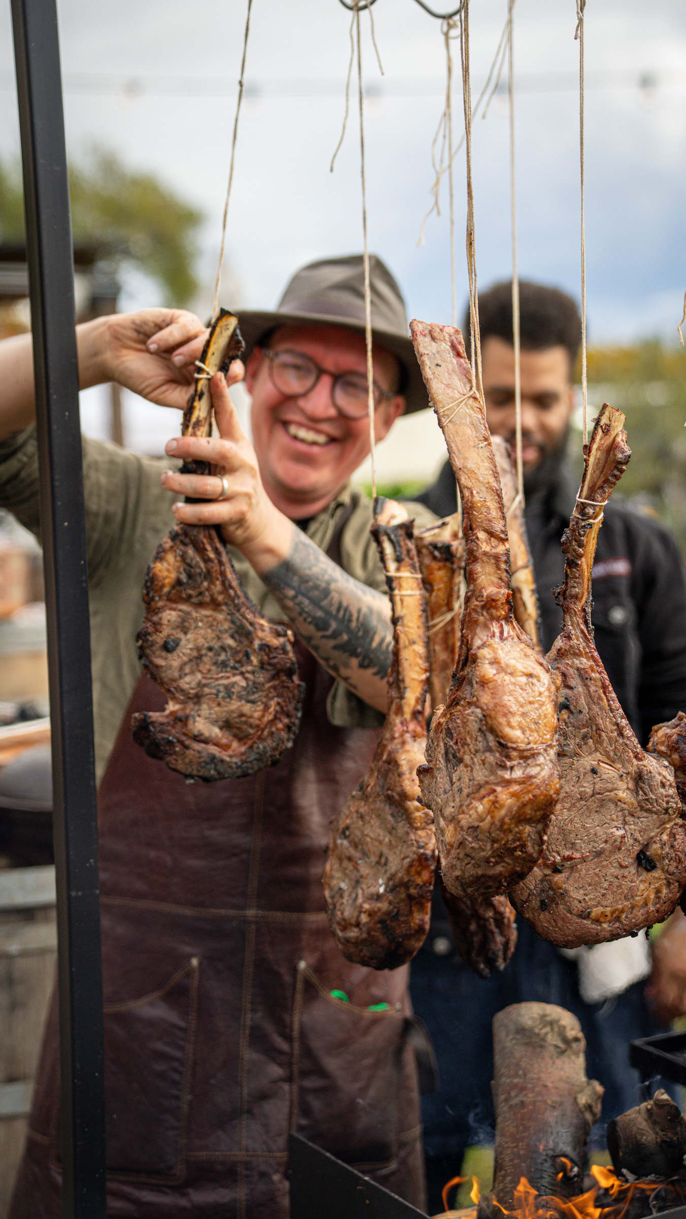 Chef lifting tomahawk steaks from the fire — Global Fire